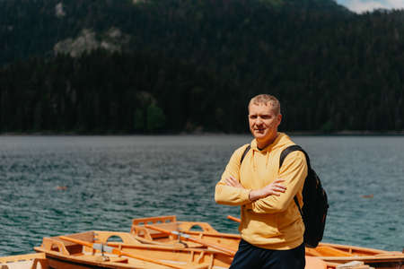 Young man looking at Black Lake, Durmitor National Park, Zabljak, Montenegro. Hipster traveler enjoying view of Black Lakeの写真素材