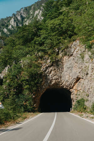 Empty route and small tunnel in mountainの写真素材