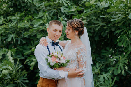 Sensual portrait of a young couple. Wedding photo outdoor. Wedding shot of bride and groom in park. Just married couple embraced.の写真素材