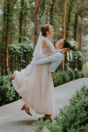 Sensual portrait of a young couple. Wedding photo outdoor. Wedding shot of bride and groom in park. Just married couple embraced.の写真素材