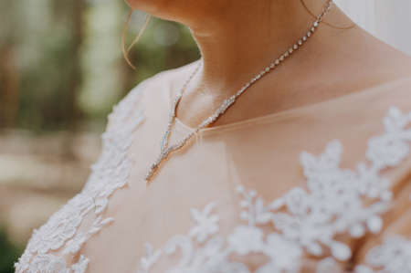 Beautiful unrecognizable bride - closeup shot. beautiful pearls on neck Bride, wedding accessories. Beautiful bride adornment.の写真素材