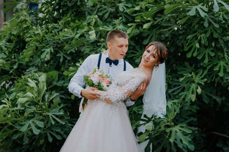 Sensual portrait of a young couple. Wedding photo outdoor. Wedding shot of bride and groom in park. Just married couple embraced.の写真素材