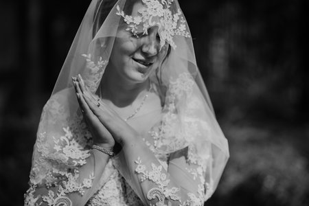Beautiful sexy bride in white dress posing under curtain. Beautiful bride under bridal veil in a...