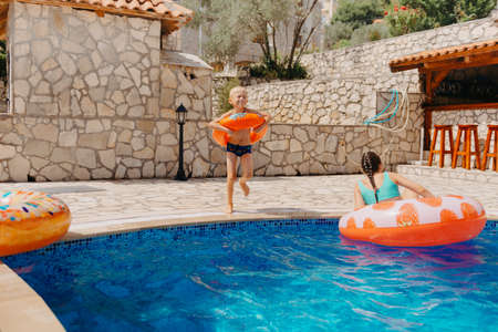 Happy child having fun on summer vacation. Kid playing with rubber duck and ball in the sea. Healthy...