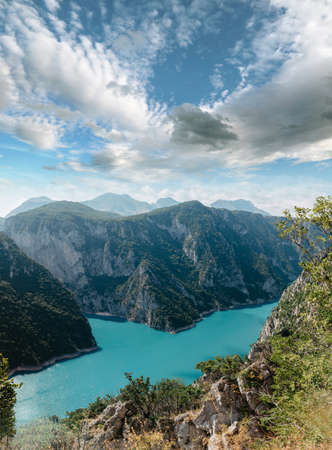 The concept of eco-tourism and active recreation. National Park. Mountain Emerald lake in the wooded mountains. Sunny day in autumnの写真素材