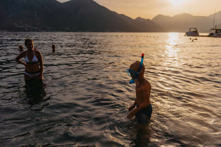 Cute happy little boy swimming and snorking in the sea. Child wearing snorkeling mask diving underwater, little boy enjoy swim underwater on tropical resortの写真素材