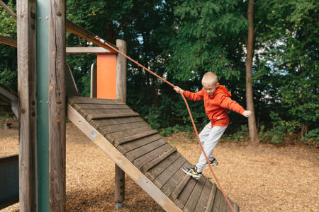 Funny cute happy baby playing on the playground. The emotion of happiness, fun, joy. Smile of a child. boy playing on the playgroundの写真素材