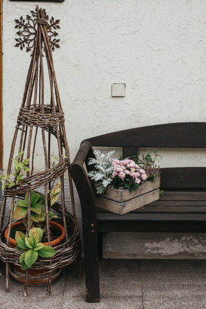 vintage outdoor furniture, mums and nik-naks. wooden bench in front garden with flower boxes. box with flowers on the bench.の写真素材