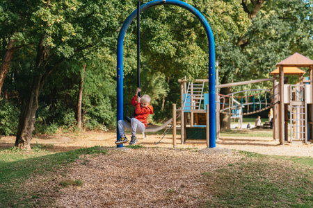 Funny cute happy baby playing on the playground. The emotion of happiness, fun, joy. Smile of a child. boy playing on the playgroundの写真素材