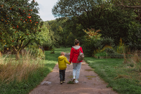 Happy family on autumn walk! Mother and son walking in the Park and enjoying the beautiful autumn nature.の写真素材