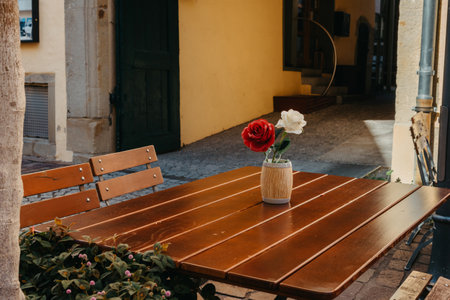 Empty cafe terrace with white table and chair. exterior of the cafe restaurant. interior Street cafe. Cozy street with flowers and French-style cafe table. Decor facade of coffeehouse with bike. Table on a summer terrace with cake and teapot. Garden table and chairsの写真素材