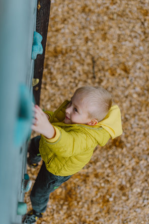 Boy At The Climbing Wall Without A Helmet, Danger At The Climbing Wall. Little Boy Climbing A Rock Wall Indoorの写真素材