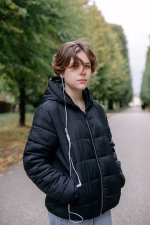 Beautiful Teenage Girl in the Park in Autumn. Portrait of a beautiful smiling girl teenager on a sunny day. Autumn season. Beauty Romantic Girl outdoor party. Beautiful teen model girl on a park. In autumn. The glow of the Sun, Sunshine. Illumination. Tintedの写真素材