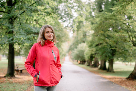 Portrait of a beautiful girl in the park in autumn. Young caucasian woman girl with toothy smile...
