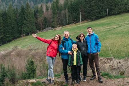 Young family enjoying their holidays in a national park. Caucasian family walking down a mountain...