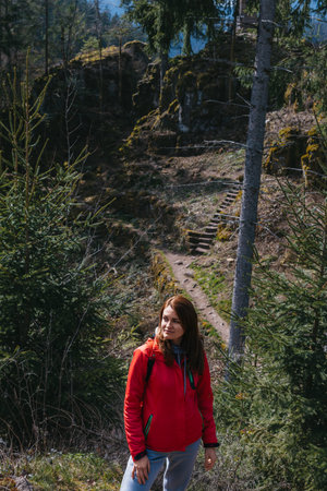 Portrait of a hipster young cute attractive girl traveler travelling in a mountain valley. Happy girl, tourist posing on the top of the mountain. Travel and vacation concept. Hiking trackの写真素材