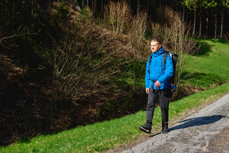 Man hiking at sunset mountains with heavy backpack Travel Lifestyle wanderlust adventure concept summer vacations outdoor alone into the wild. Hipster man traveler wanderer wearing travelling alone and enjoying freedom and calm inspired travellingの写真素材