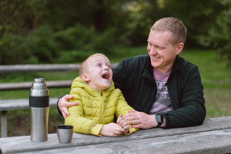 Happy Family: Father And Child Boy Son Playing And Laughing In Autumn Park, Sitting On Wooden Bench And Table. Father And Little Kid Having Fun Outdoors, Playing Together. Father And Son Sitting On A Bench And Talking.の写真素材