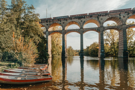 Railway Bridge with river in Bietigheim-Bissingen, Germany. Autumn. Railway viaduct over the Enz River, built in 1853 by Karl von Etzel on a sunny summer day. Bietigheim-Bissingen, Germany. Old viaduct in Bietigheim reflected in the river. Baden-Wurttemberg, Germany. Train passing a train bridge on a cloudy day in Germanyの写真素材