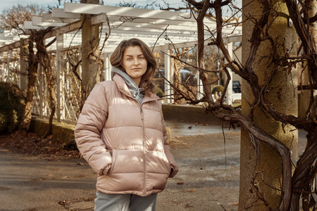 Young beautiful pretty tourist girl in warm hat and coat with backpack walking at cold autumn in Europe city enjoying her travel in Bietigheim-Bissingen, Deutschland. Outdoor portrait of young tourist woman enjoying sightseeingの写真素材