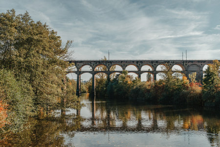 Railway Bridge with river in Bietigheim-Bissingen, Germany. Autumn. Railway viaduct over the Enz River, built in 1853 by Karl von Etzel on a sunny summer day. Bietigheim-Bissingen, Germany. Old viaduct in Bietigheim reflected in the river. Baden-Wurttemberg, Germany. Train passing a train bridge on a cloudy day in Germanyの写真素材