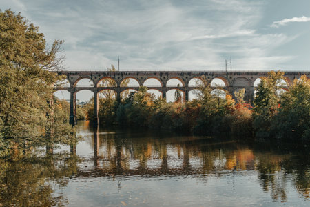 Railway Bridge with river in Bietigheim-Bissingen, Germany. Autumn. Railway viaduct over the Enz River, built in 1853 by Karl von Etzel on a sunny summer day. Bietigheim-Bissingen, Germany. Old viaduct in Bietigheim reflected in the river. Baden-Wurttemberg, Germany. Train passing a train bridge on a cloudy day in Germanyの写真素材