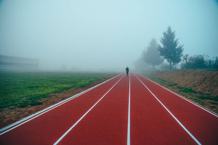 Running track over blue misty sky. Morning run