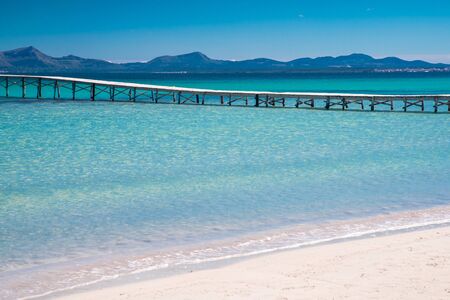 Summer holiday concept photo. Sea and empty pier Beautiful clear tropical beach, white sand and blue water. Spain.の写真素材