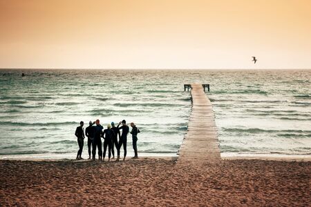 A group of divers together by the sea in summer mornig light.の写真素材