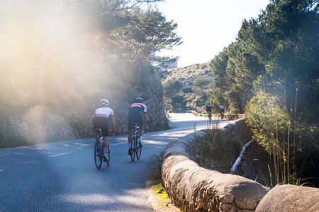 Athlete on road bicycle ride up hill in summer nature.の写真素材