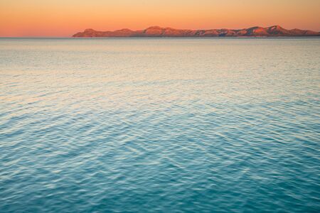 Summer evening sea. Blue water and colorful sunrise sky.の写真素材