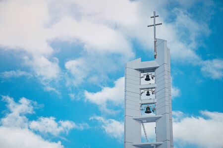 Christianity Church tower, cross and big bells, blue edit space