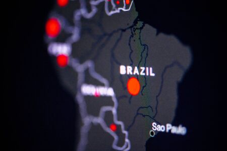 Brazil, Sao Paulo, . Coronavirus COVID-19 global cases Map. Red Dot showing the number of infected. Johns Hopkins University map on monitor display.の写真素材