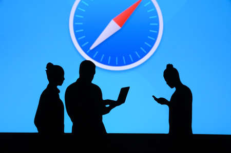 NEW YORK, USA, 25. MAY 2020: Safari graphical web browser developed by Apple Group of business people chat on mobile phone and laptop. Company logo on screen in backgroundのeditorial素材
