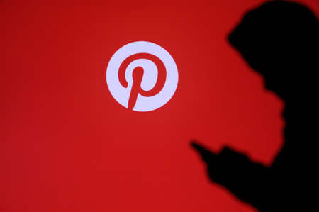 NEW YORK, USA, 25. MAY 2020: Pinterest American image sharing and social media service Young boy chat on mobile phone. Company logo on screen in backgroundのeditorial素材