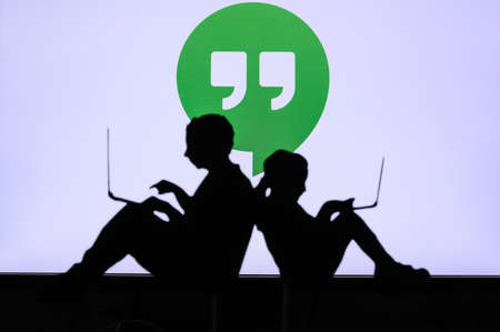 NEW YORK, USA, 25. MAY 2020: Hangout, communication software developed by Google Children silhouette, sitting together and playing on their laptops. Company logo on screen in backgroundのeditorial素材