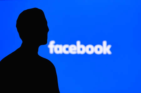 NEW YORK, USA, 25. MAY 2020: Mark Zuckerberg silhouette, Facebook tittle on blue display in background.のeditorial素材