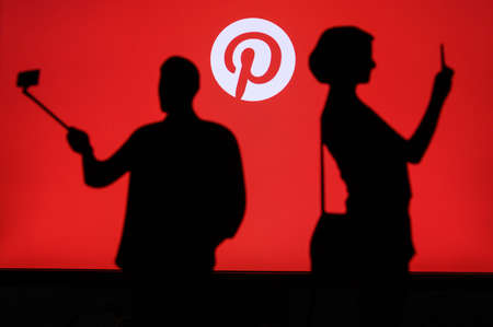 NEW YORK, USA, 25. MAY 2020: Pinterest American image sharing and social media service. Couple taking a photo on a mobile man use a selfie stick. Company logo on screen in backgroundのeditorial素材