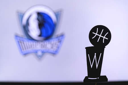 NEW YORK, USA, JUN 18, 2020: Dallas Mavericks Basketball club on the white screen. Silhouette of NBA trophy in foreground.のeditorial素材