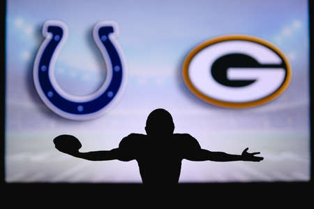 Indianapolis Colts vs. Green Bay Packers. NFL Game. American Football League match. Silhouette of professional player celebrate touch down. Screen in background.のeditorial素材