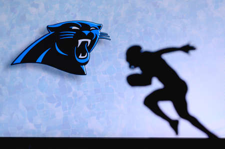Carolina Panthers. Silhouette of professional american football player. Logo of NFL club in background, edit space.のeditorial素材
