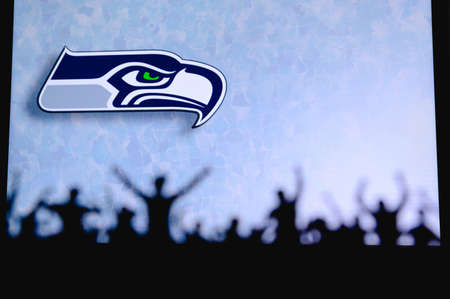 Seattle Seahawks. Fans support professional team of American National Foorball League. Silhouette of supporters in foreground. Logo on the big screen.のeditorial素材