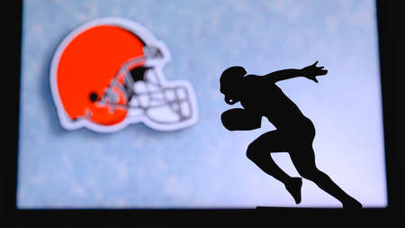 Cleveland Browns. Silhouette of professional american football player. Logo of NFL club in background, edit space.のeditorial素材