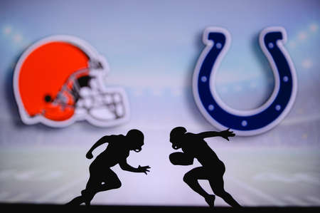 Cleveland Browns vs. Indianapolis Colts. NFL match poster. Two american football players silhouette facing each other on the field. Clubs logo in background. Rivalry concept photo.のeditorial素材