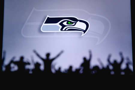 Seattle Seahawks. Fans support professional team of American National Foorball League. Silhouette of supporters in foreground. Logo on the big screen.のeditorial素材