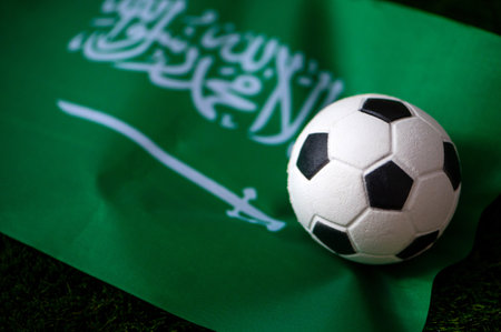 Saudi Arabia national football team. National Flag on green grass and soccer ball. Football...