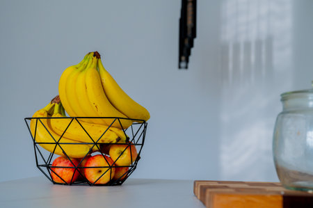 A glass bowl on the kitchen counter cradles a banana in gentle daylightの写真素材