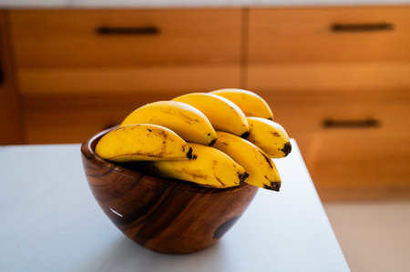 A sunny kitchen moment: banana placed on the tableの写真素材