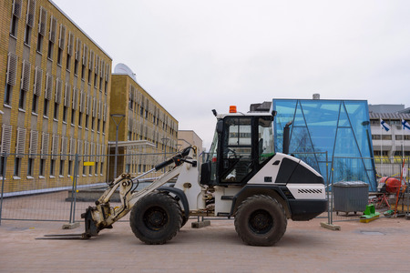 tractor manipulator stands in the city near the construction site.