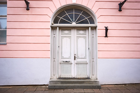 Old wooden door painted with white paint in old buildingの写真素材